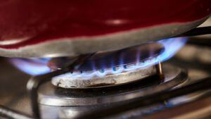 Detail of a gas stove lit with a blue flame