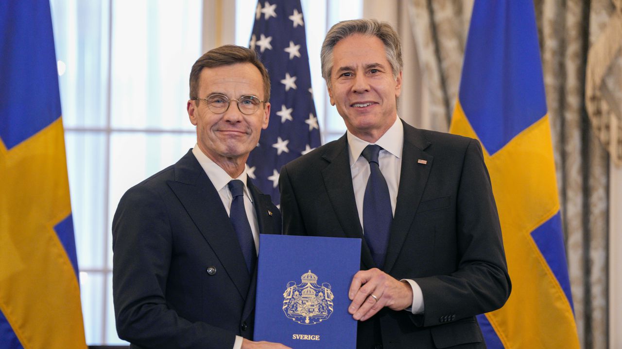 El secretario de Estado, Antony Blinken, a la derecha, posa para una fotografía con el primer ministro sueco, Ulf Kristersson, sosteniendo los instrumentos de adhesión de Suecia a la OTAN en la sala Benjamin Franklin del Departamento de Estado, el jueves 7 de marzo de 2024