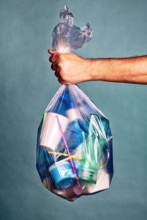 La mano sostiene una bolsa con basura plástica