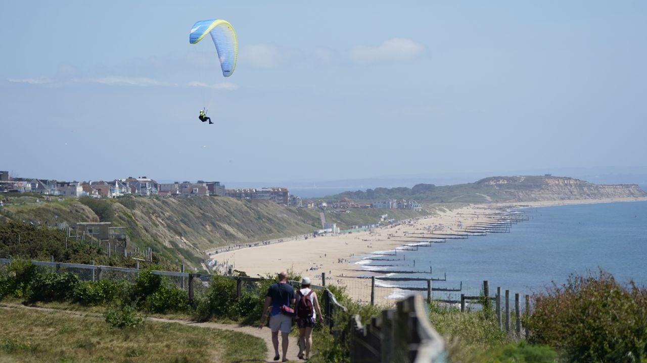 Heat haze softens the scene as a paraglider takes to the sky over the cliffs above Boscombe beach in Dorset. Temperatures are warming up for the weekend as most of Britain can expect to be bathed in sunshine. However, the Met Office warned that a sun-kissed Saturday, which would be ideal for a barbecue, could be followed by heavy rain and thunderstorms. Picture date: Saturday May 14, 2022. (Photo by Andrew Matthews/PA Images via Getty Images)
