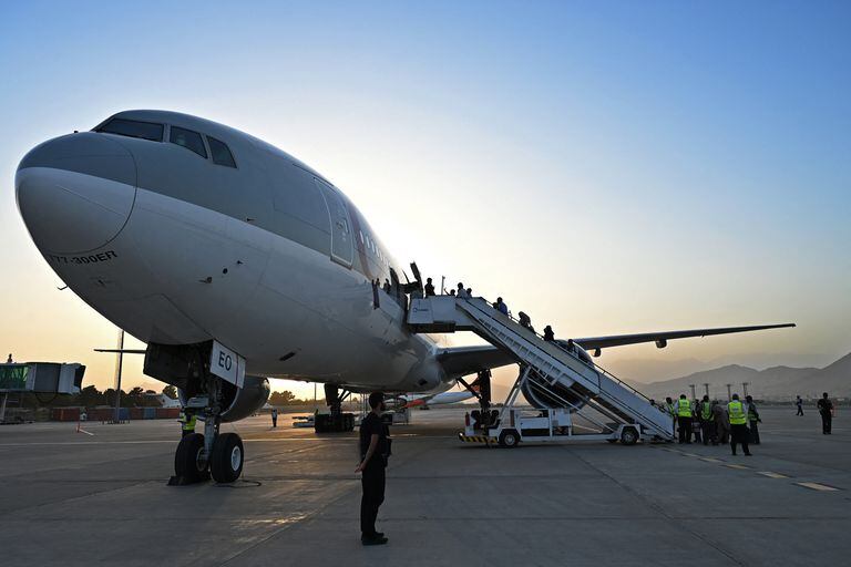 Passengers board a Qatar Airways aircraft at the airport in Kabul on September 9, 2021. - Some 200 passengers, including US citizens, left Kabul airport on September 9, 2021, on the first flight carrying foreigners out of the Afghan capital since a US-led evacuation ended on August 30. (Photo by WAKIL KOHSAR / AFP)