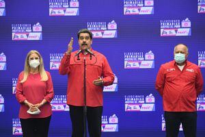Venezuelan President Nicolas Maduro (C) accompanied by his wife Cilia Flores (L) and Venezuelan deputy Diosdado Cabello (R) at a polling station in Simon Rodriguez school in Fuerte Tiuna, Caracas, on August 8, 2021 during the Socialist United Party of Venezuela (PSUV) primary elections to choose candidates ahead of the November's mayor and governor election. (Photo by Federico PARRA / AFP)