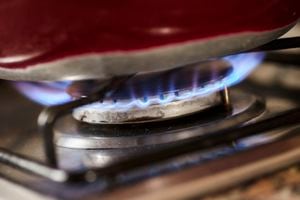 Detail of a gas stove lit with a blue flame