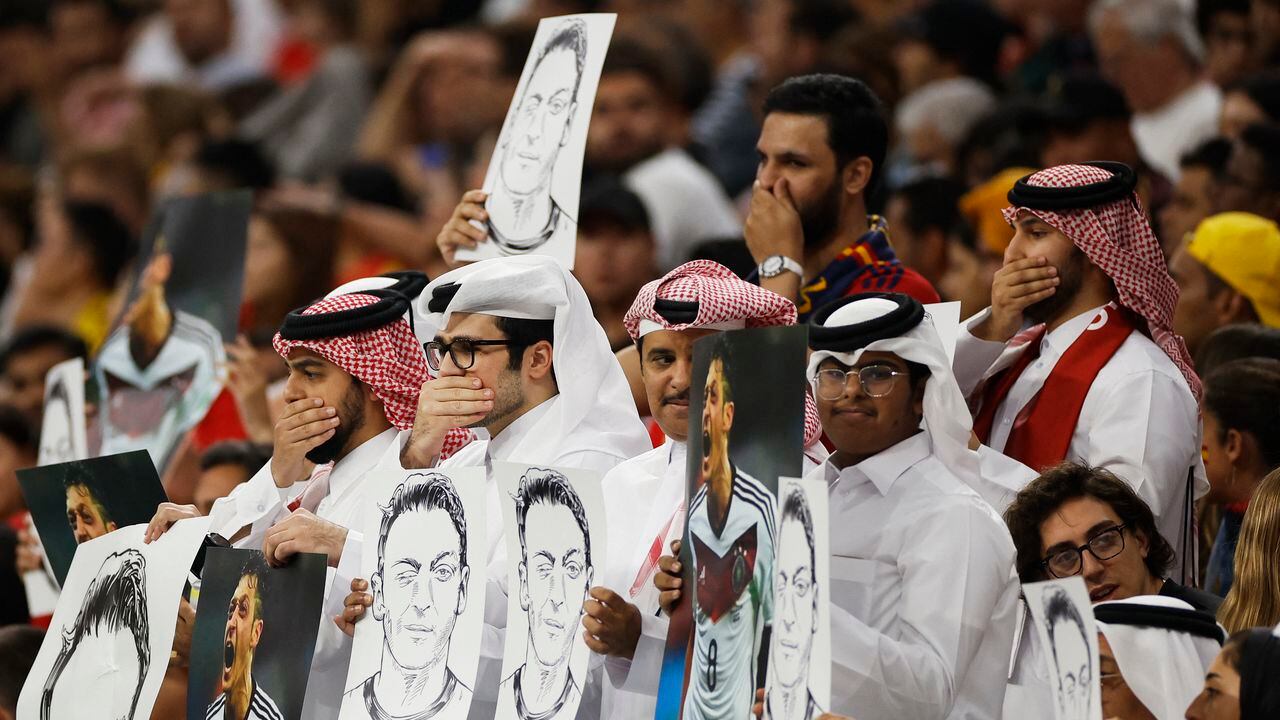 Soccer Football - FIFA World Cup Qatar 2022 - Group E - Spain v Germany - Al Bayt Stadium, Al Khor, Qatar - November 27, 2022 Fans hold up signs displaying former Germany player Mesut Ozil in the stands REUTERS/John Sibley