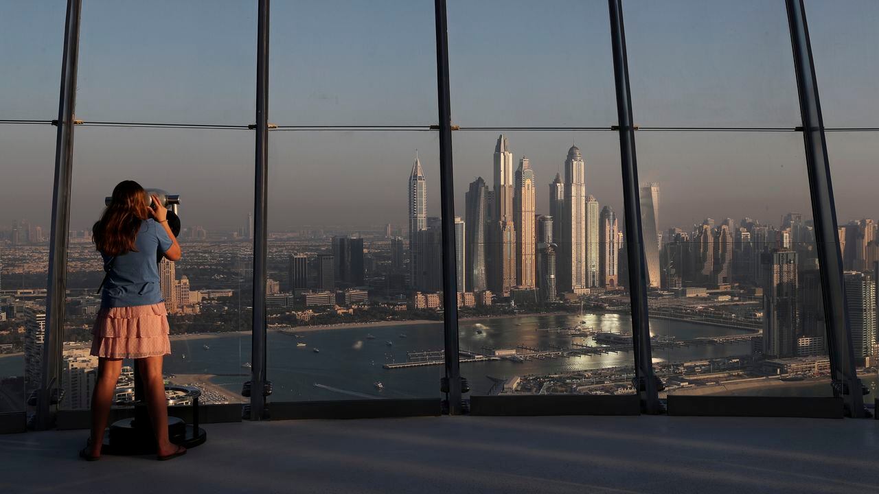 Una mujer observa la vista de las torres del distrito de Marina desde la plataforma de observación de "The View at The Palm Jumeirah" en Dubai, Emiratos Árabes Unidos. (AP Photo / Kamran Jebreili)