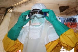 (ARCHIVOS) Esta foto de archivo tomada el 28 de junio de 2014 muestra a un miembro de Médicos Sin Fronteras (MSF) poniéndose equipo de protección en la sala de aislamiento del Hospital Donka en Conakry, donde reciben tratamiento las personas infectadas con el virus del Ébola. - La Organización Mundial de la Salud el 19 de junio de 2021 anunció oficialmente el final del segundo brote de ébola en Guinea, que se declaró el 14 de febrero.
Fue el segundo brote de este tipo en el país desde la devastadora epidemia de ébola de 2013-2016 en África occidental, que dejó 11.300 muertos en Guinea, Liberia y Sierra Leona. (Foto de CELLOU BINANI / AFP)