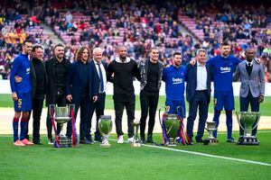 BARCELONA, SPAIN - DECEMBER 21: (L-R) Sergio Busquets, Gaby Milito, Xavi Torres, Carles Puyol, Carles Naval, Seydou Keita, Jose Manuel Pinto, Lionel Messi, Aureli Altimira, Gerard Pique and Eric Abidal pose with the six trophies won by FC Barcelona in 2009 before the La Liga match between FC Barcelona and Deportivo Alaves at Camp Nou on December 21, 2019 in Barcelona, Spain.  (Photo by Quality Sport Images/Getty Images)