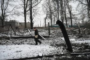 An elderly man passes by wreckage of a building after reported shelling in Kyiv on March 2, 2022. - Ukraine's President Volodymyr Zelensky on March 2 accused Russia, which has launched an invasion of his country, of seeking to "erase" Ukrainians, their country and their history. (Photo by ARIS MESSINIS / AFP)