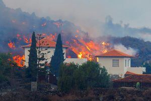 La lava fluye detrás de una casa tras la erupción de un volcán en el parque nacional Cumbre Vieja en Los Llanos de Aridane, en la isla canaria de La Palma, el 20 de septiembre de 2021. Foto REUTERS / Borja Suarez