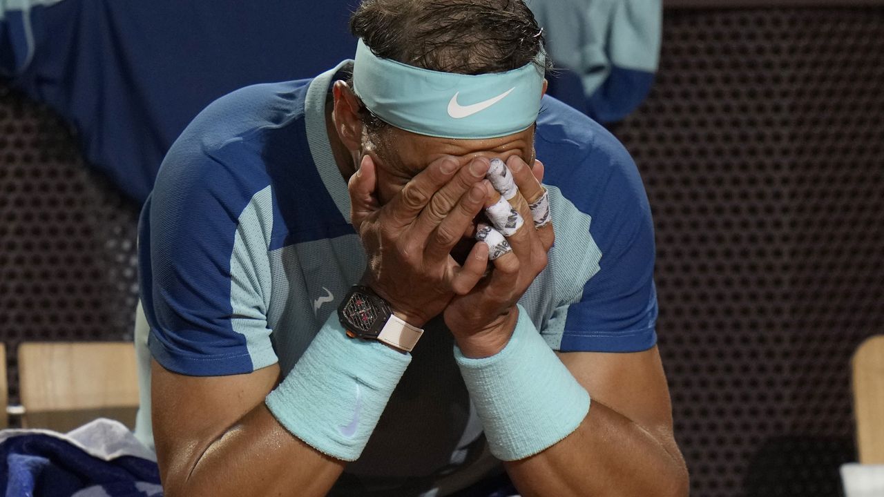 Rafael Nadal of Spain touches his face during his match against Denis Shapovalov of Canada at the Italian Open tennis tournament, in Rome, Thursday, May 12, 2022. Shapovalov beat Nadal 1-6, 7-5, 6-2. (AP Photo/Alessandra Tarantino)