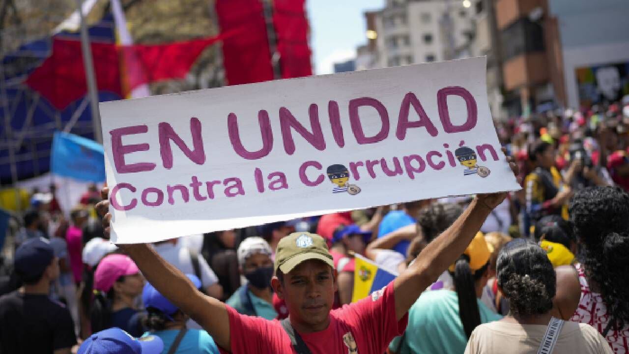Un simpatizante del gobierno venezolano sostiene un cartel con un mensaje que dice: "En unidad contra la corrupción", durante una manifestación en Caracas.