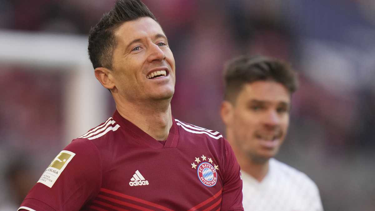 Bayern's Robert Lewandowski smiles after scoring the opening goal of the game from the penalty spot during the German Bundesliga soccer match between Bayern Munich and Augsburg at the Allianz Arena, in Munich Germany, Saturday, April 9, 2022. (AP Photo/Matthias Schrader )