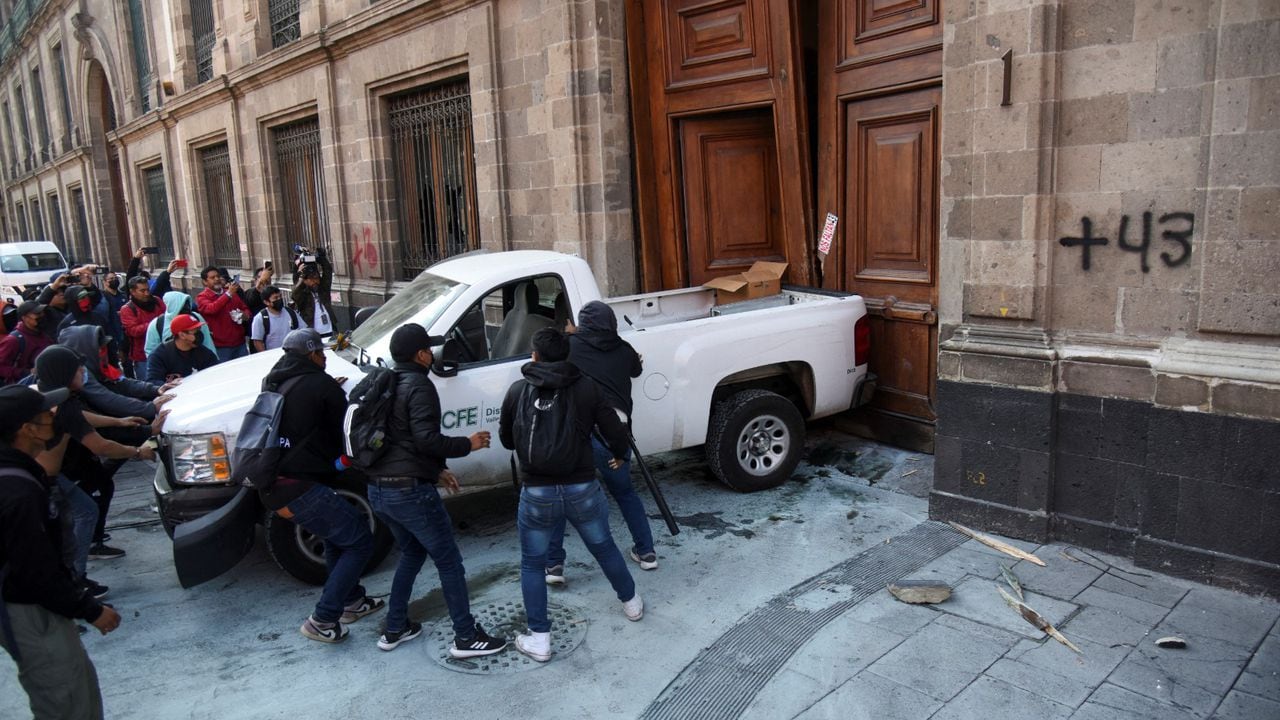 Unos manifestantes derriban con una camioneta una puerta del palacio presidencial en Ciudad de México el 6 de marzo de 2024