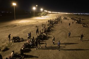 En una vista aérea, los inmigrantes esperan cerca de la valla fronteriza entre Estados Unidos y México, con la esperanza de que los agentes fronterizos de Estados Unidos procesen su asilo el 8 de mayo de 2023 en El Paso, Texas.