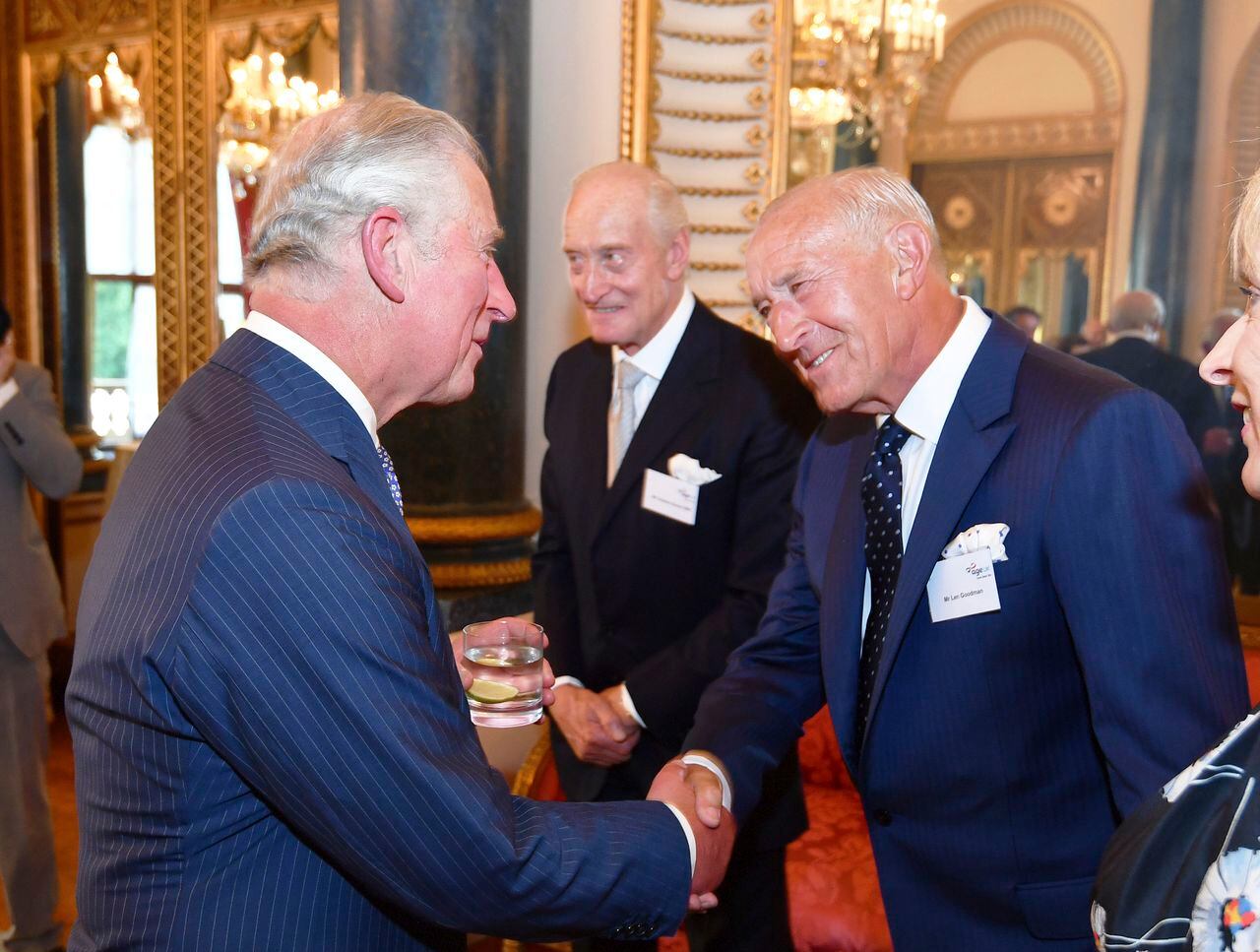 El príncipe Carlos de Gran Bretaña, a la izquierda, le da la mano a Len Goodman, durante una recepción para Age UK en el Palacio de Buckingham en Londres, el 6 de junio de 2018.