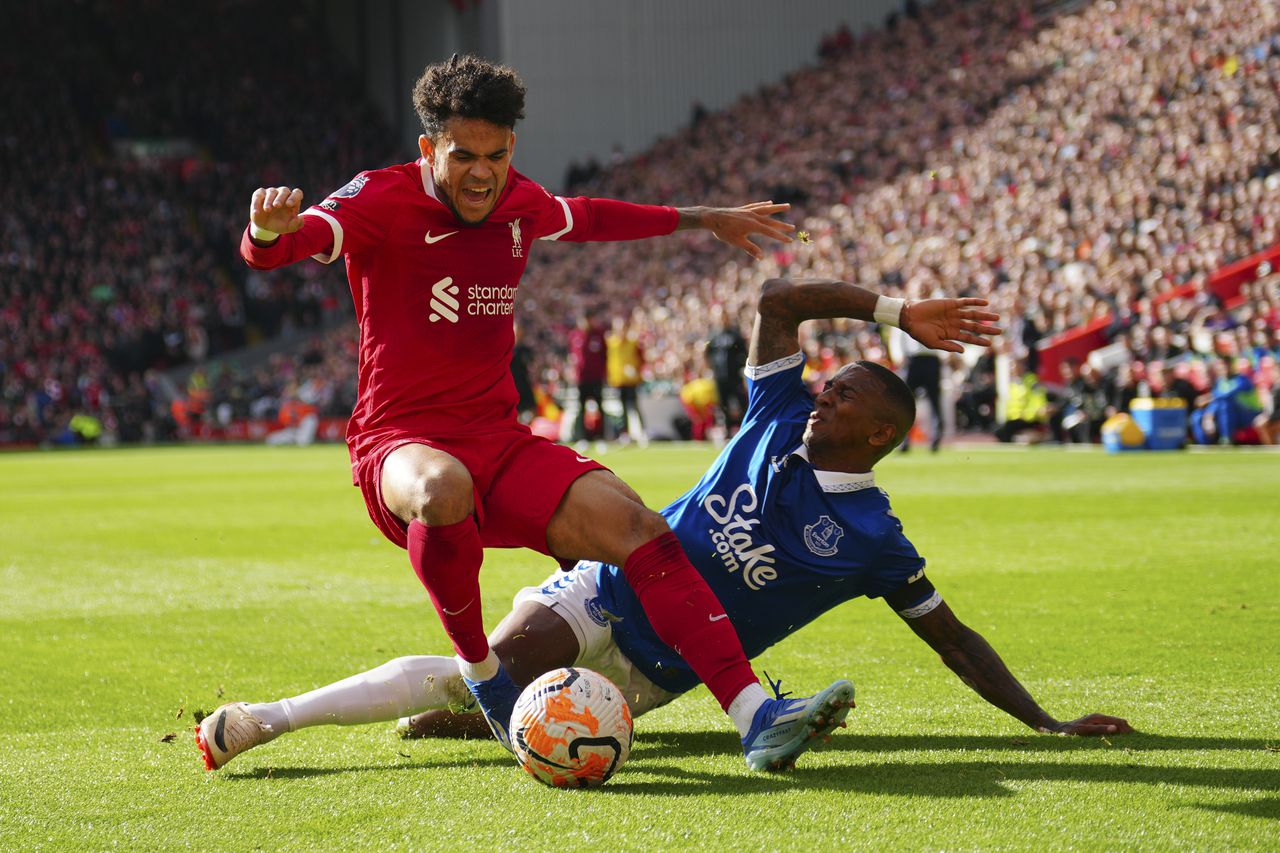 Liverpool's Luis Diaz, left, challenges for the ball with Everton's Ashley Young during the English Premier League soccer match between Liverpool and Everton, at Anfield in Liverpool, England, Saturday, Oct. 21, 2023. (AP Photo/Jon Super)