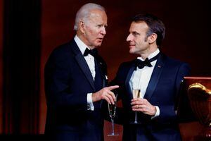 FILE PHOTO: U.S. President Joe Biden speaks to France's President Emmanuel Macron while they make a toast, as the Bidens host the Macrons for a State Dinner at the White House, in Washington, U.S., December 1, 2022.  REUTERS/Evelyn Hockstein/File Photo