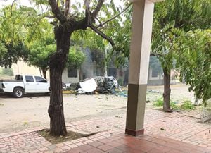 Frente a la camioneta blanca, se logra ver un vehículo completamente destruido por la explosión, además de algunas hojas y ramas en medio de la calle.