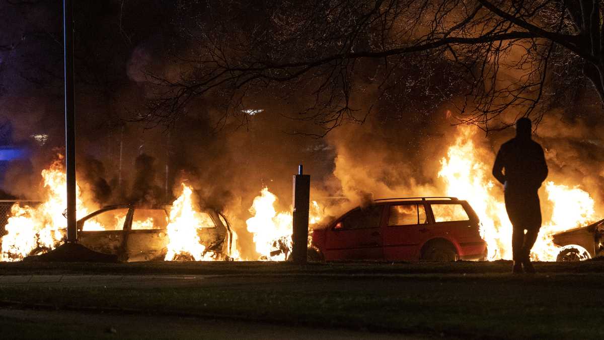 Varios vehículos son arrasados por las llamas tras el estallido de protestas en Rosengard, distrito de Malmö, Suecia, la noche del domingo 17 de abril de 2022.