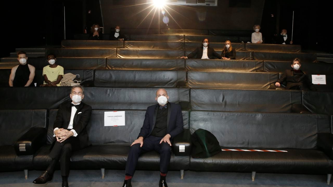 Nominees, including: Yorgos Lamprinos, bottom center, Adrien Merigeau, center left, Amaury Ovise, center right, Nicolas Becker, center, Jean-Louis Livi, top right, and Florian Zeller, top second left, attend a screening of the Oscars on Monday April 26, 2021 in Paris, France. (AP Photo/Lewis Joly, Pool)