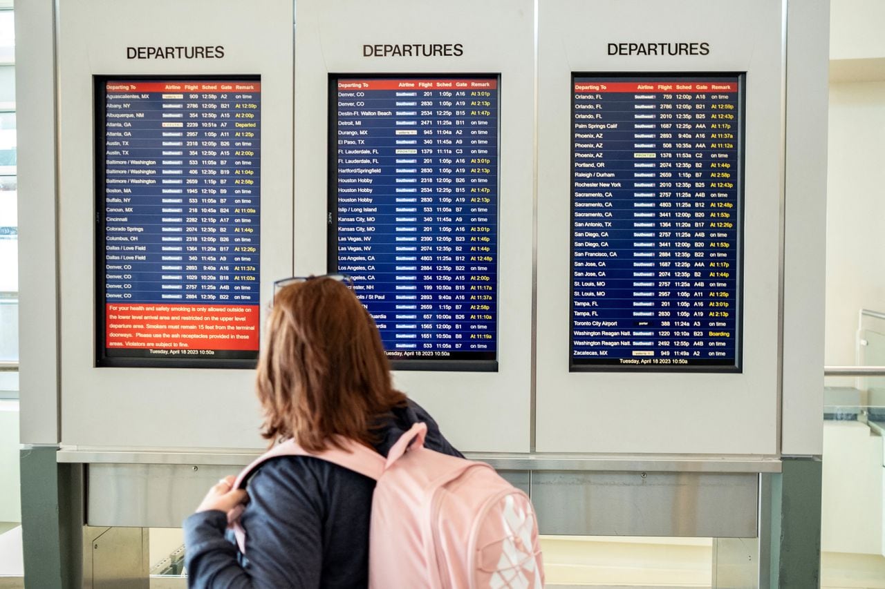 Una mujer revisa el tablero de llegadas y salidas después de que se reanudaron los vuelos de Southwest Airlines tras el levantamiento de un breve paro nacional causado por un problema técnico interno, según la Autoridad Federal de Aviación (FAA) de EE. UU.