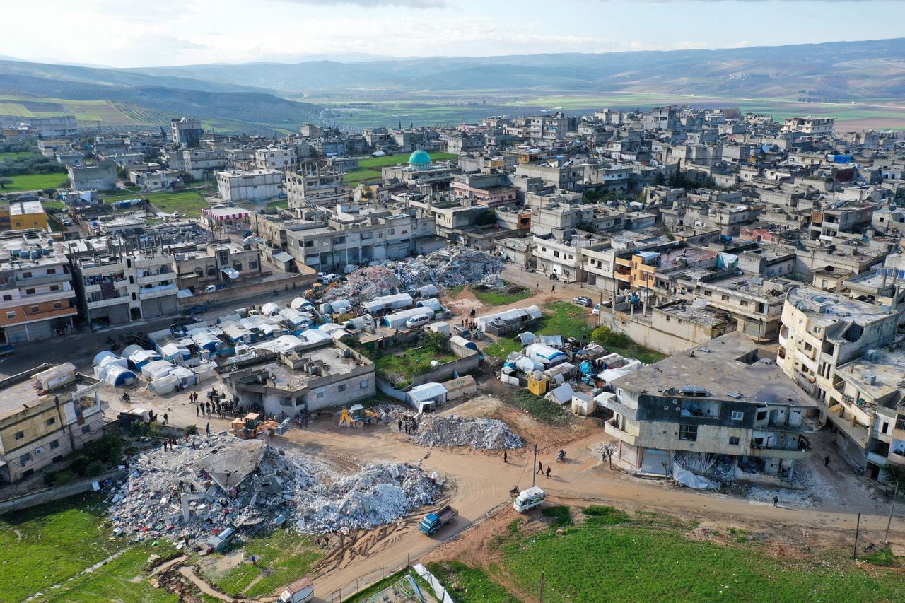 An aerial picture shows rescuers searching the rubble of buildings for casualties and survivors in the village of Azmarin in Syria's rebel-held northwestern Idlib province at the border with Turkey following an earthquake, on February 7, 2023. (Photo by Omar HAJ KADOUR / AFP)