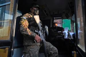 A soldier is seen on a public transport bus in San Salvador on March 16, 2022. - The government intervened two routes of collective transport after the illegal increase in the cost of the ticket by now captured transport entrepreneur Catalino Miranda, who is also charged with the crimes of resistance and public disorder. (Photo by MARVIN RECINOS / AFP)