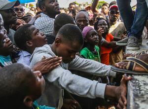 Un joven llora mientras espera un saco de arroz que se está distribuyendo a los residentes en Les Cayes, Haití, lunes, 16 de agosto de 2021, dos días después de un terremoto de 7.2-magnitud golpeó a la parte suroeste de la nación más pobre del Hemisferio el 14 de agosto. . (AP Foto / Joseph Odelyn)