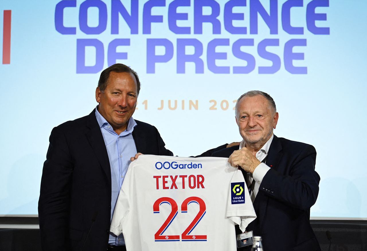 (FILES) Lyon football club president Jean-Michel Aulas (R) and US businessman John Textor pose at the end of a press conference to announce the sell of a major stake of the club to Textor's Eagle Football Holdings, in Decines-Charpieu, near Lyon, on June 21, 2022. - Olympique Lyonnais French president Jean-Michel Aulas announced he is stepping down from his position, on May 8, 2023, and will be replaced by John Textor. (Photo by OLIVIER CHASSIGNOLE / AFP)