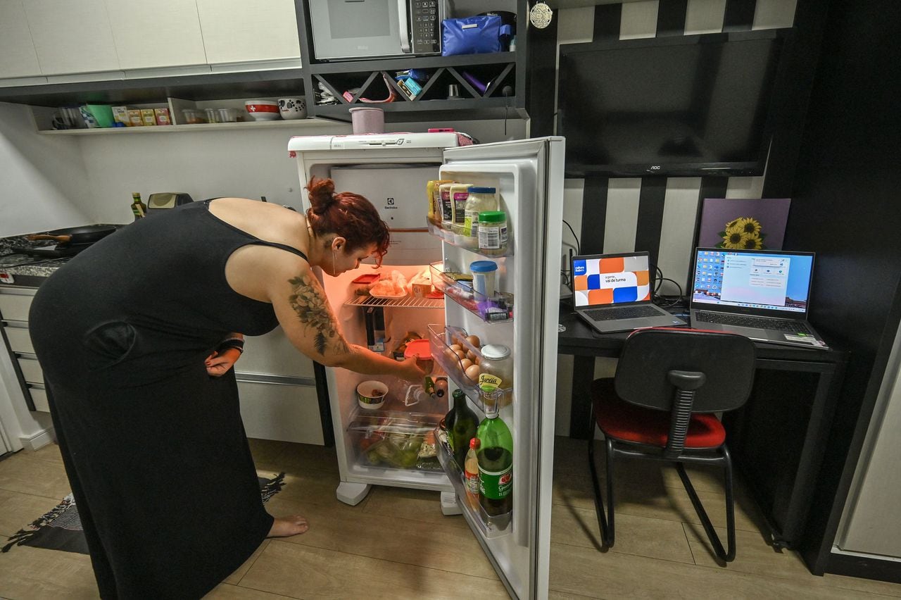 Lara Maia revisa su refrigerador en su microapartamento de 16 metros cuadrados, en el centro de Sao Paulo, Brasil.