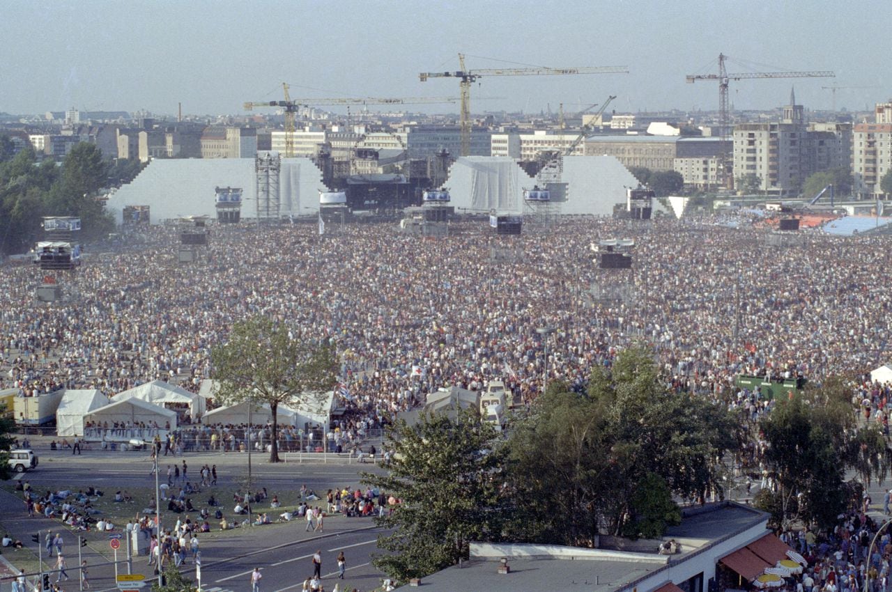PRESENTADA - 21 de julio de 1990, Berlín: Los espectadores se paran en la antigua franja de la muerte en Potsdamer Platz y esperan la producción de Roger Waters del éxito de Pink Floyd "The Wall". (a "Espectáculo de rock en la tira de la muerte -" El Muro "hace 30 años en Berlín") Foto: Peter Kneffel / dpa (Foto de PETER KNEFFEL / DPA / dpa Picture-Alliance vía AFP)