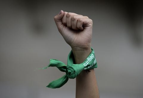 (FILES) In this file picture taken on March 9, 2020 a woman rises her fist with a green headscarves to demand the legalization of abortion during a demonstration in front of the Congress in Buenos Aires during a women's strike in Argentina. - The Argentine Congress debates on a government-backed new draft bill to legalize abortion on December 1, 2020, an issue that has bitterly divided the traditionally Catholic South American nation. Under a law first passed in 1920, Argentina permits abortions only in cases of rape or danger to the life of the mother. (Photo by Juan MABROMATA / AFP)