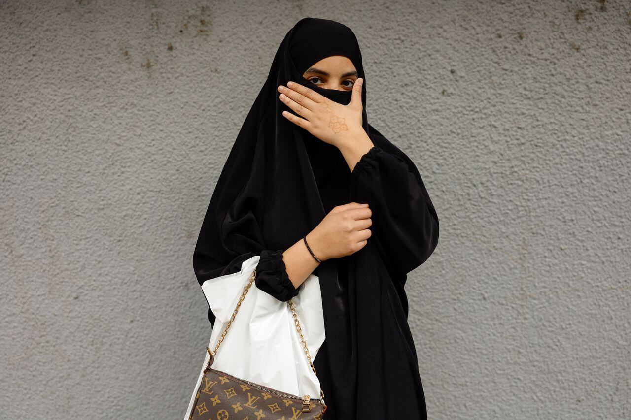 Una mujer es vista con Hijab mientras la gente hace compras durante el mes santo del Ramadán en el distrito de Val Fourre de la campiña de Mantes-la-Jolie en París, Francia, el 24 de marzo de 2023