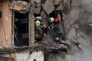 El personal de emergencia evacua a una mujer en el sitio donde un bloque de apartamentos resultó gravemente dañado por un ataque con misiles rusos, en medio del ataque de Rusia a Ucrania, en Dnipro, Ucrania, el 15 de enero de 2023. 