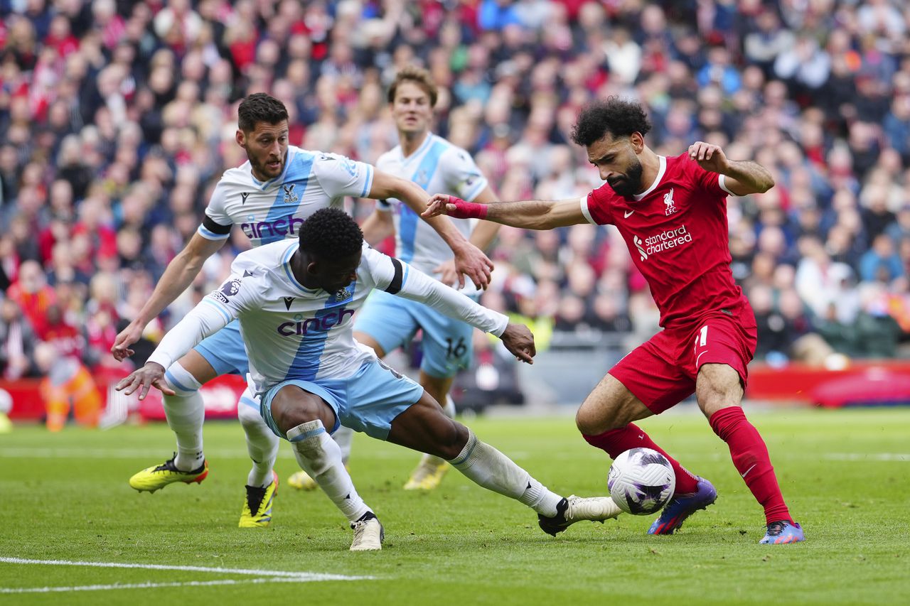Liverpool's Mohamed Salah, right, challenges for the ball with Crystal Palace's Jefferson Lerma during the English Premier League soccer match between Liverpool and Crystal Palace at Anfield Stadium in Liverpool, England, Sunday, April 14, 2024. (AP Photo/Jon Super)