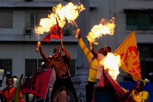 Los manifestantes usan aerosoles para avivar las llamas de sus antorchas mientras marchan hacia la Asamblea Nacional en la Ciudad de Panamá, el martes 12 de julio de 2022. Foto AP/Arnulfo Franco
