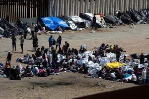 Migrantes se reúnen entre las cercas primaria y secundaria de la frontera entre Estados Unidos y México antes del levantamiento del Título 42, visto desde Tijuana, México, 11 de mayo de 2023. 