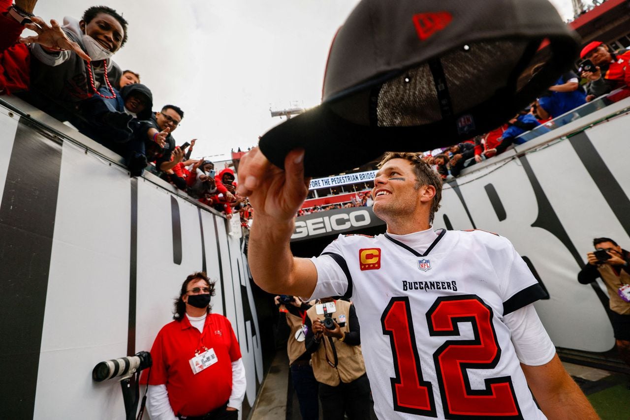 FILE PHOTO: Jan 16, 2022; Tampa, Florida, USA; Tampa Bay Buccaneers quarterback Tom Brady (12) hands his hat to a fan after beating the Philadelphia Eagles 31-15 in a NFC Wild Card playoff football game at Raymond James Stadium. Mandatory Credit: Nathan Ray Seebeck-USA TODAY Sports/File Photo