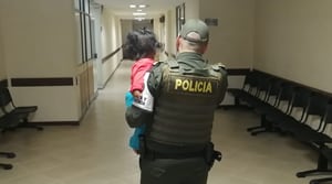 Bebé de nueve meses abandonada en Medellín, mientras es cargada por un policía.