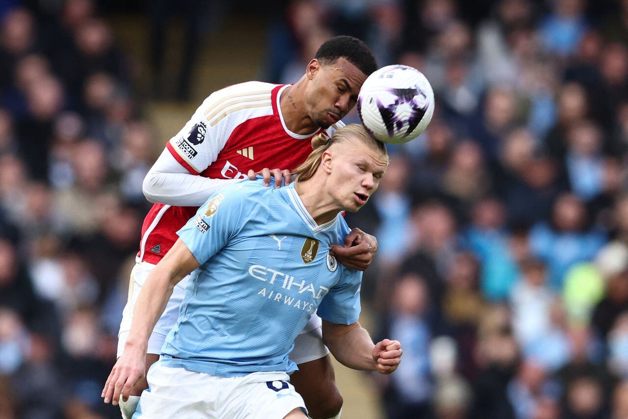 Magalhaes (L) fights for the ball with Manchester City's Norwegian striker #09 Erling Haaland during the English Premier League football match between Manchester City and Arsenal at the Etihad Stadium in Manchester, north west England, on March 31, 2024. (Photo by Darren Staples / AFP) / RESTRICTED TO EDITORIAL USE. No use with unauthorized audio, video, data, fixture lists, club/league logos or 'live' services. Online in-match use limited to 120 images. An additional 40 images may be used in extra time. No video emulation. Social media in-match use limited to 120 images. An additional 40 images may be used in extra time. No use in betting publications, games or single club/league/player publications. /