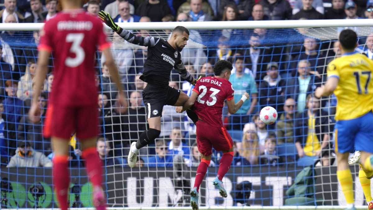 Liverpool's Luis Diaz, right, scores his side's first goal as Brighton's goalkeeper Robert Sanchez jumps during the English Premier League soccer match between Brighton and Hove Albion and Liverpool at the Amex stadium in Brighton, England, Saturday, March 12, 2022. (AP/Kirsty Wigglesworth)