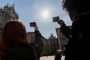 La gente mira el sol, esperando erróneamente un eclipse, durante un eclipse lunar parcial en otras partes del mundo, en Catania, Italia, el 19 de noviembre de 2021. Foto REUTERS / Antonio Parrinello.