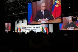 Russian President Vladimir Putin addresses leaders from the BRICS group of emerging economies at the start of a three-day summit in Johannesburg, South Africa , Tuesday, Aug. 22, 2023. Putin appeared on a video link after his travel to South Africa was complicated by an International Criminal Court arrest warrant against him over the war in Ukraine. (AP Photo/Jerome Delay)