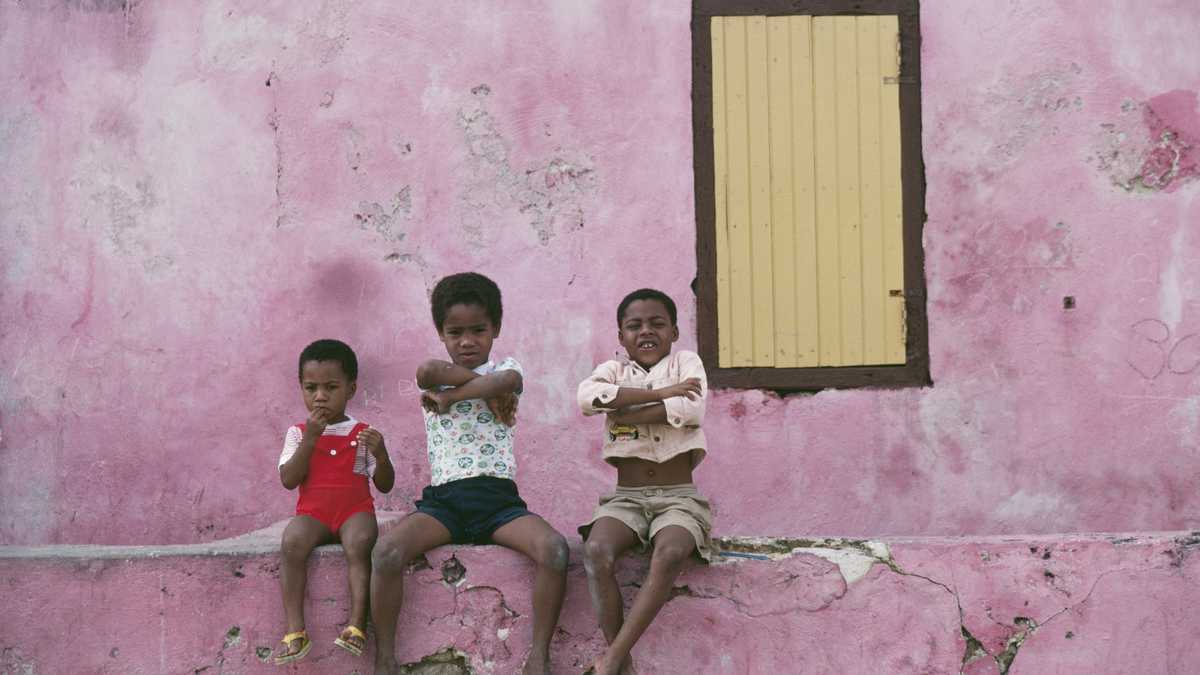 Three local children sitting on a low wall, Curacao, Netherlands Antilles, January 1979.  (Photo by Slim Aarons/Getty Images)