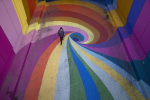 Una mujer camina por el Paseo Bandera de colores arcoíris en Santiago, Chile, el martes 27 de abril de 2021, sin visitantes en medio de la nueva pandemia de coronavirus. (Foto AP / Esteban Felix)