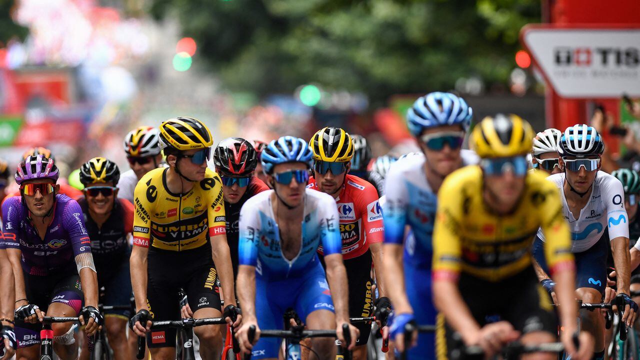 Team Jumbo's Slovenian rider Primoz Roglic (C), wearing the overall leader's red jersey, crosses the finish line with the pack during the 5th stage of the 2022 La Vuelta cycling tour of Spain, a 187.2 km race from Irun to Bilbao, on August 24, 2022. (Photo by ANDER GILLENEA / AFP)