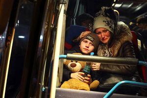 Una mujer llora mientras consuela a su hijo después de saber que tiene que dejar un autobús reservado para la evacuación de los huérfanos que huyen de la invasión rusa en curso fuera de la estación principal de tren en Lviv, Ucrania, el 5 de marzo de 2022. Foto REUTERS/Kai Pfaffenbach