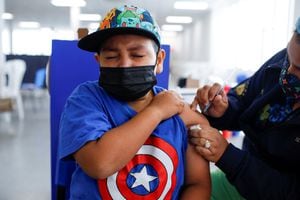 Javier Emmanuelle Salegio Miranda 9 años reacciona al recibir su primera dosis de la vacuna contra la enfermedad del coronavirus Sinopharm (COVID-19) en el centro de vacunación del Hospital El Salvador en San Salvador, El Salvador. Foto REUTERS / José Cabezas.