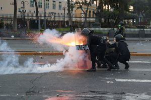 Un oficial de la policía antidisturbios dispara un arma mientras los manifestantes participan en una protesta para exigir la renuncia de la presidenta de Perú, Dina Boluarte, en Lima, Perú, el 28 de enero de 2023. 