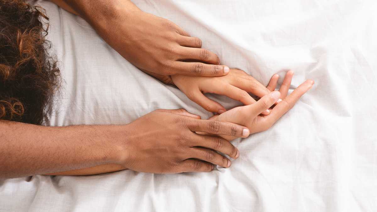 Black man and woman enjoying sexual foreplay in bed, free space